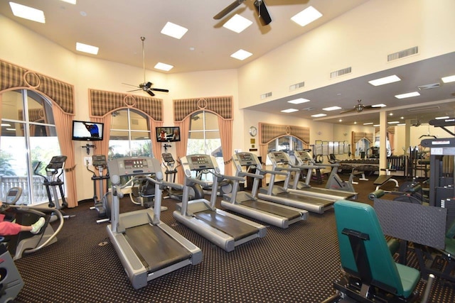 workout area with a towering ceiling and ceiling fan