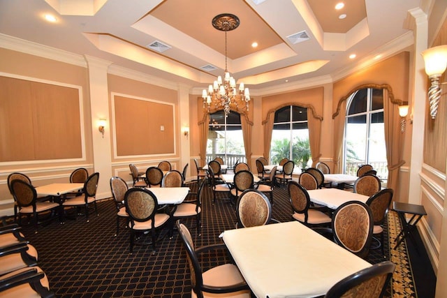 carpeted dining room with a raised ceiling, crown molding, and an inviting chandelier