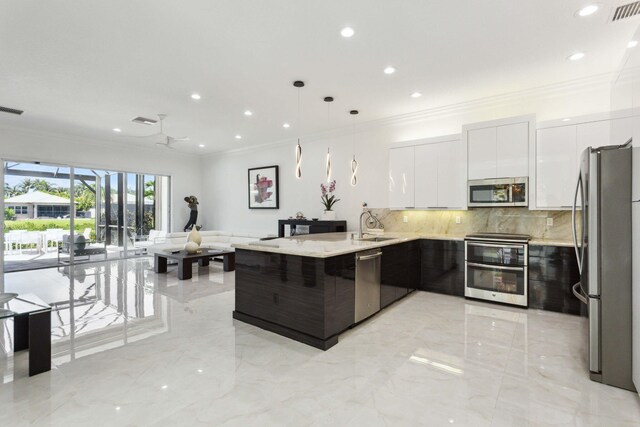 kitchen featuring appliances with stainless steel finishes, decorative backsplash, sink, white cabinetry, and decorative light fixtures