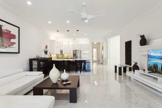 living room with ceiling fan, crown molding, and sink