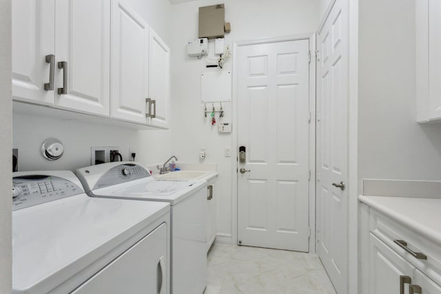 laundry room with light tile patterned flooring, washing machine and clothes dryer, and cabinets