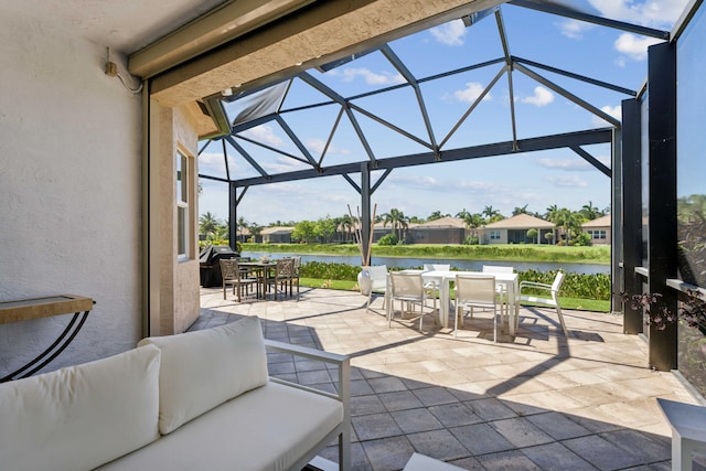 view of patio / terrace with a lanai, a water view, and an outdoor hangout area