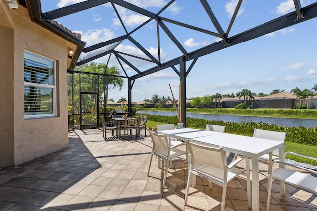 view of patio / terrace with glass enclosure and a water view