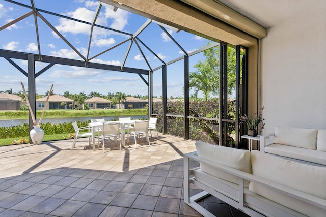 view of patio with a lanai, an outdoor living space, and a water view