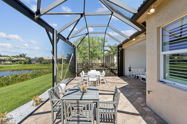 view of patio / terrace featuring a lanai and a water view