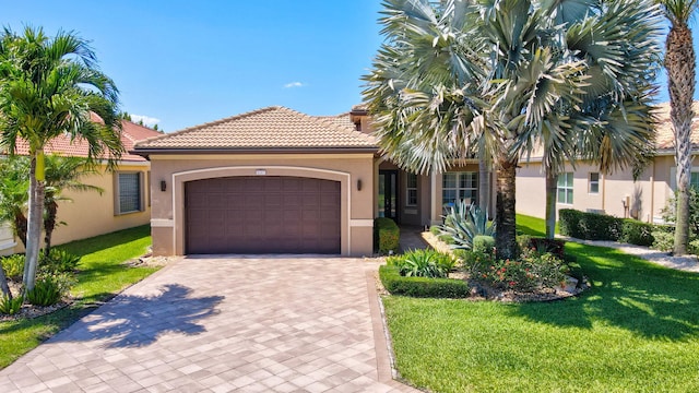 mediterranean / spanish-style home featuring a front lawn and a garage