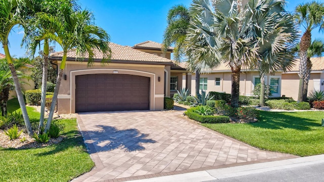 mediterranean / spanish home with a garage and a front lawn