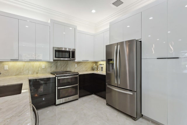 kitchen with light stone countertops, stainless steel appliances, tasteful backsplash, white cabinets, and sink