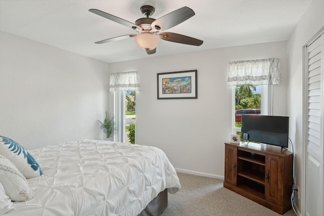 carpeted bedroom featuring ceiling fan and multiple windows