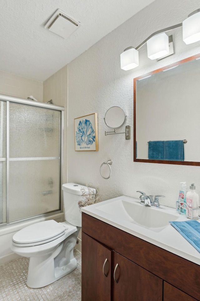 full bathroom featuring vanity, tile patterned floors, toilet, enclosed tub / shower combo, and a textured ceiling