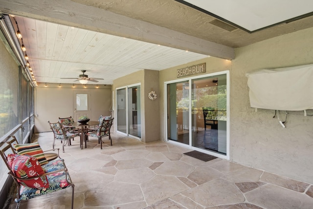 sunroom / solarium featuring ceiling fan and wooden ceiling