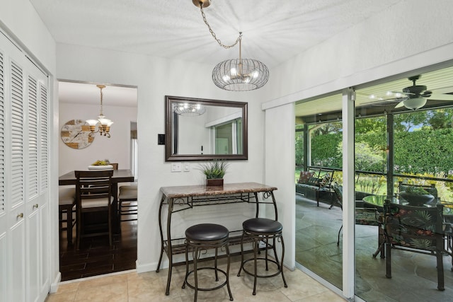 interior space featuring light tile patterned floors and ceiling fan with notable chandelier