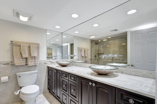 bathroom with vanity, an enclosed shower, tile walls, and toilet