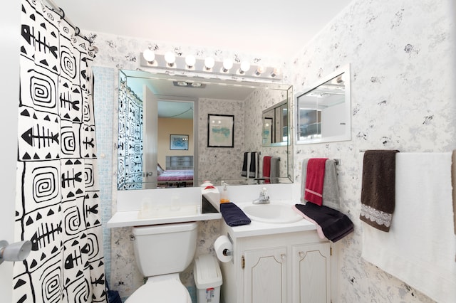 bathroom with tile walls, toilet, and large vanity