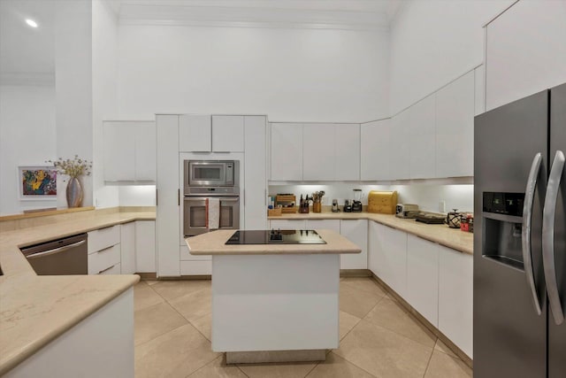 kitchen with white cabinets, a high ceiling, and stainless steel appliances