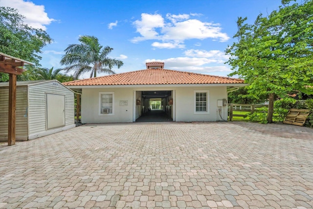 back of property featuring a storage unit