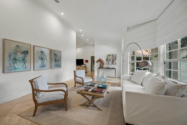 living room featuring light tile patterned floors, a towering ceiling, and ornamental molding