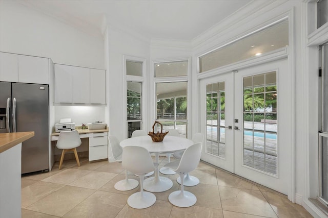 tiled dining space featuring crown molding and french doors