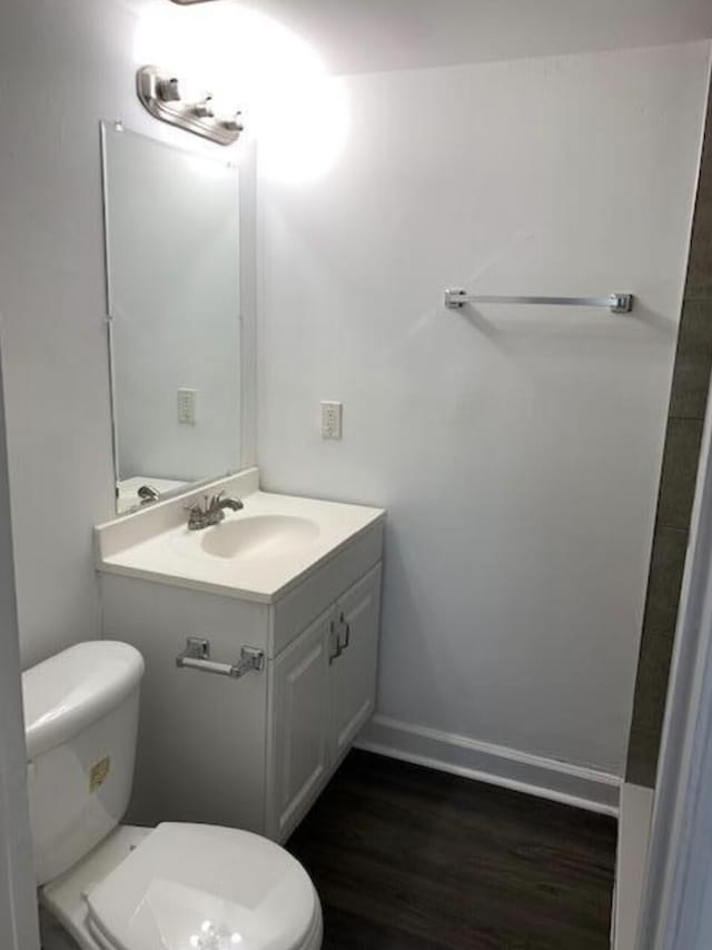 bathroom featuring vanity, hardwood / wood-style floors, and toilet