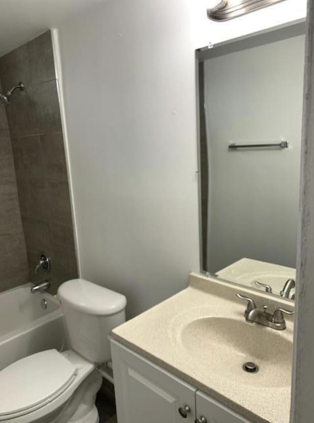 full bathroom with tiled shower / bath combo, vanity, and toilet