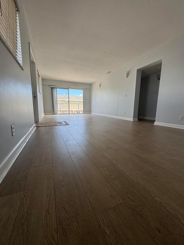 unfurnished living room with dark hardwood / wood-style flooring