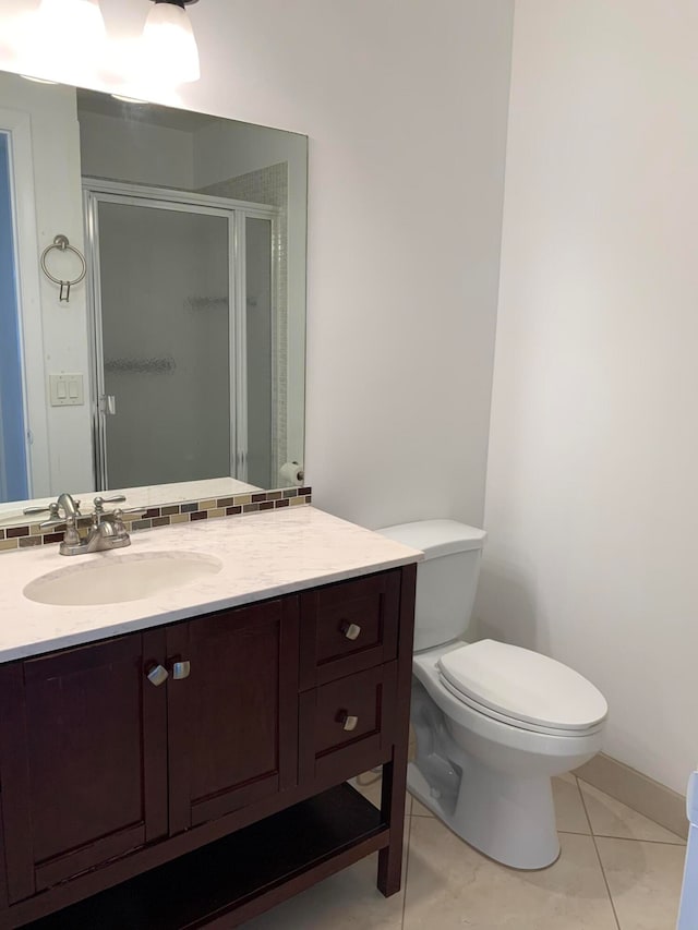 bathroom with tile flooring, toilet, and vanity