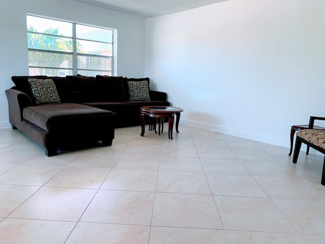 living room with a textured ceiling and light tile floors