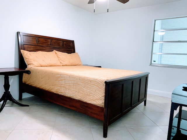 tiled bedroom featuring ceiling fan