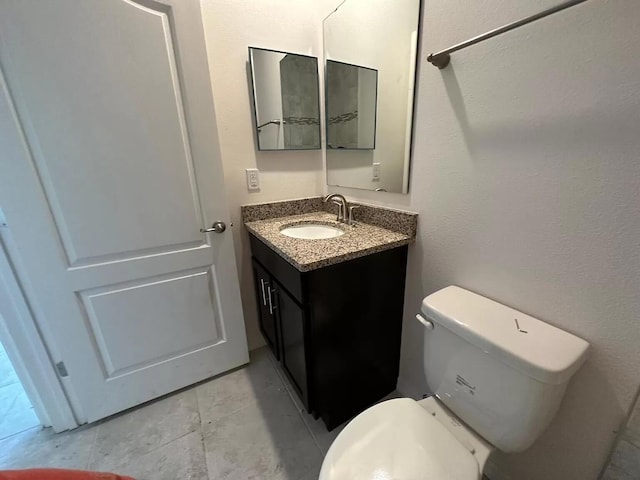 bathroom featuring tile floors, toilet, and vanity