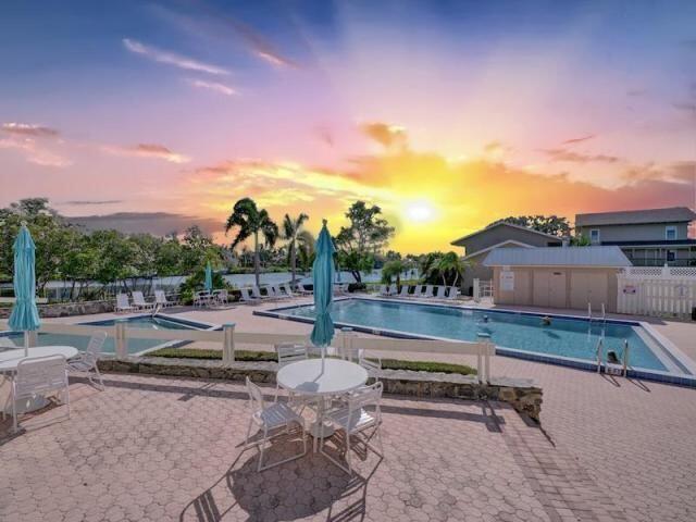 pool at dusk featuring a patio