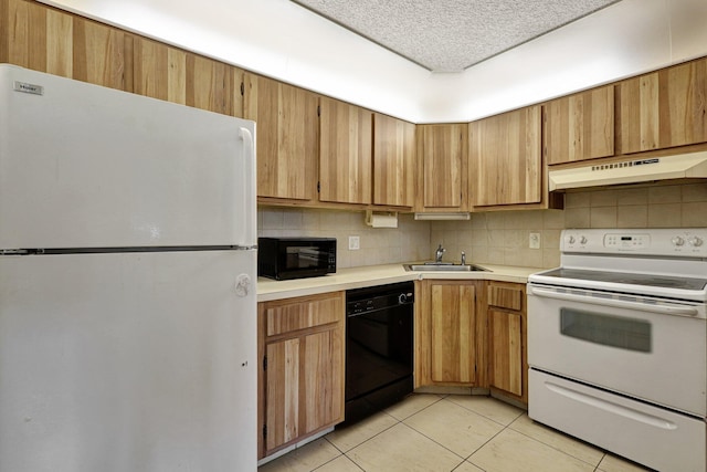 kitchen featuring light tile flooring, black appliances, tasteful backsplash, and premium range hood