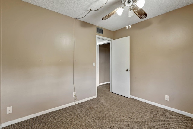 carpeted spare room with ceiling fan and a textured ceiling