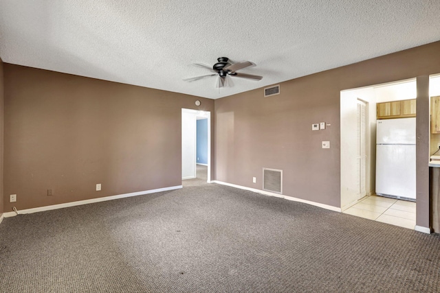 carpeted empty room featuring ceiling fan and a textured ceiling