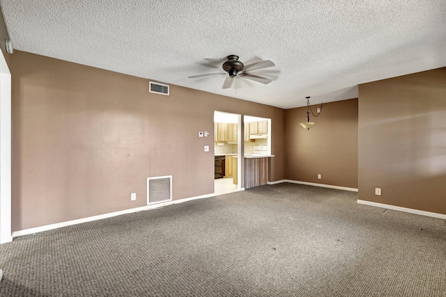 spare room featuring a textured ceiling, ceiling fan, and carpet floors