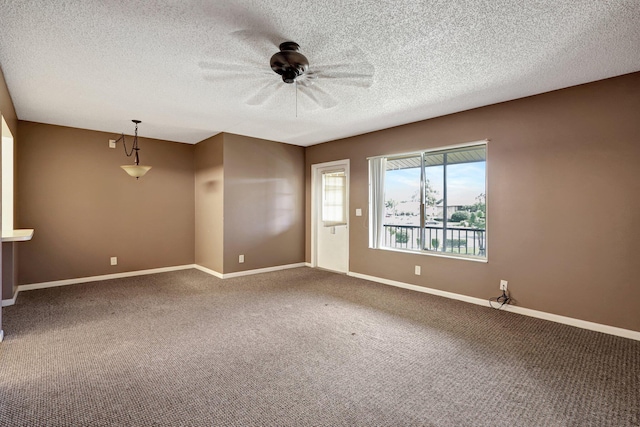 empty room featuring a textured ceiling, ceiling fan, and dark carpet