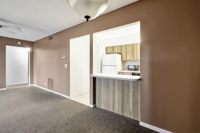 carpeted empty room featuring a textured ceiling