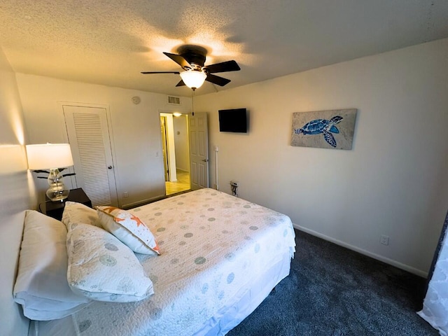 carpeted bedroom with a textured ceiling, a closet, and ceiling fan