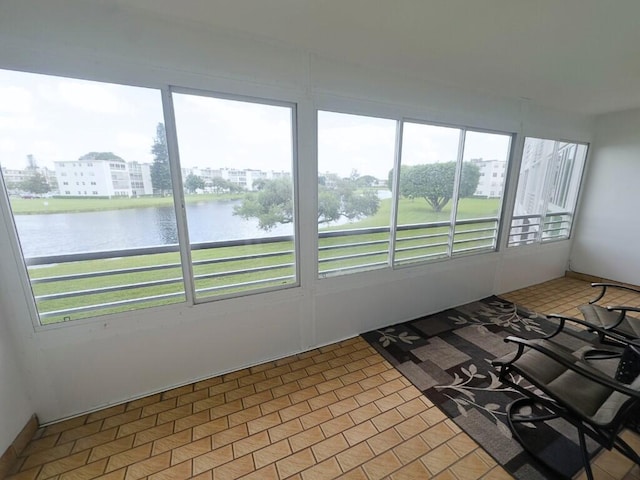 unfurnished sunroom with plenty of natural light and a water view