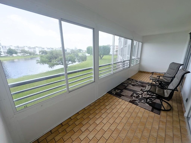 sunroom featuring a water view