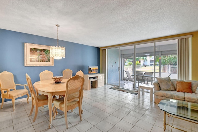 dining area featuring a notable chandelier, light tile floors, and a textured ceiling