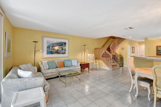 living room featuring a textured ceiling and light tile floors