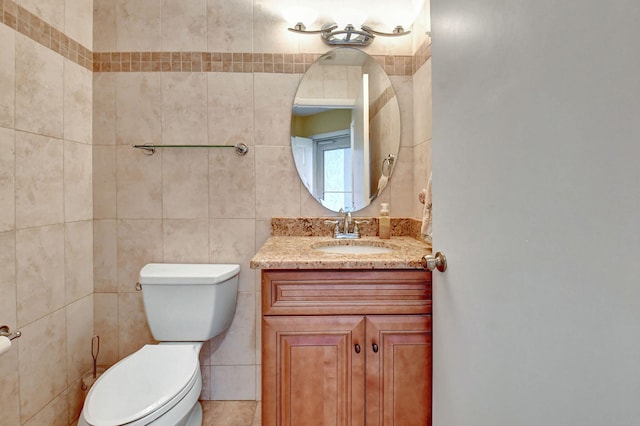 bathroom featuring tile walls, tile floors, large vanity, and toilet