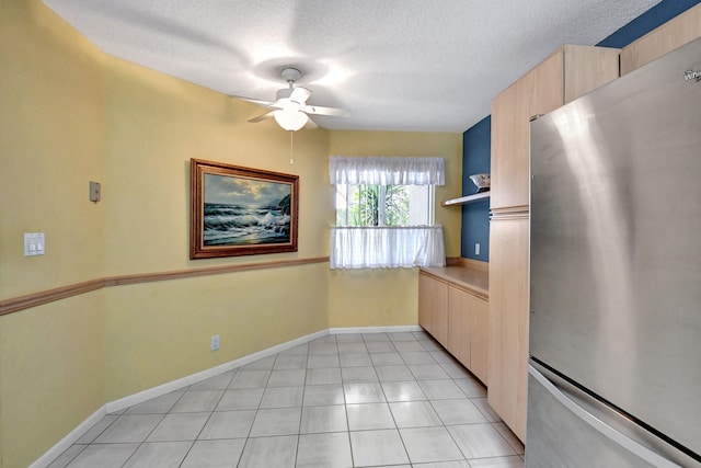 kitchen featuring light brown cabinets, ceiling fan, stainless steel fridge, and light tile floors