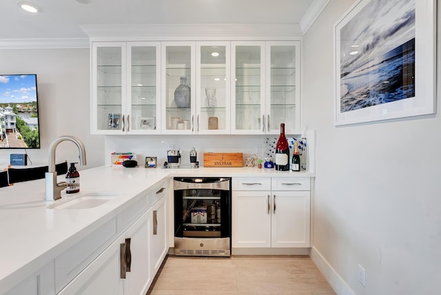 bar with crown molding, white cabinetry, sink, and wine cooler