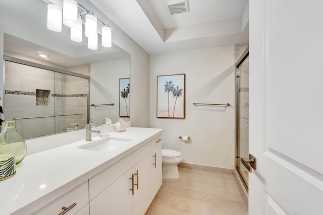 bathroom with vanity, toilet, and a shower with shower door