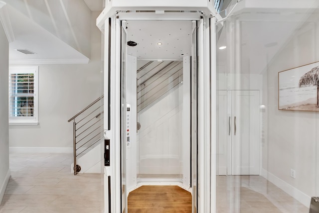 stairs featuring elevator and ornamental molding