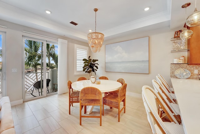 dining room with ornamental molding, a raised ceiling, and a notable chandelier