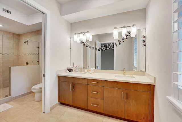 bathroom featuring tile patterned floors, vanity, toilet, and an enclosed shower