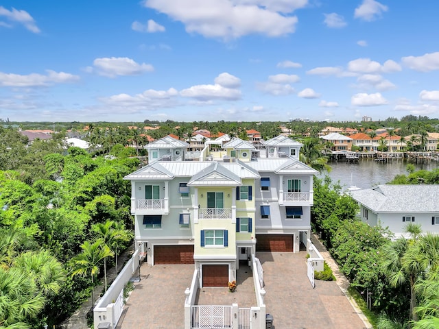 view of front facade with a water view, a garage, and a balcony