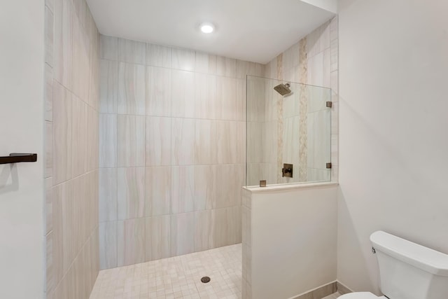 bathroom with toilet and a tile shower